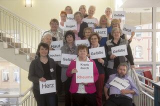 Gruppenfoto mit Schildern auf denen Organe stehen Treffen Rheuma Liga rheumaliga